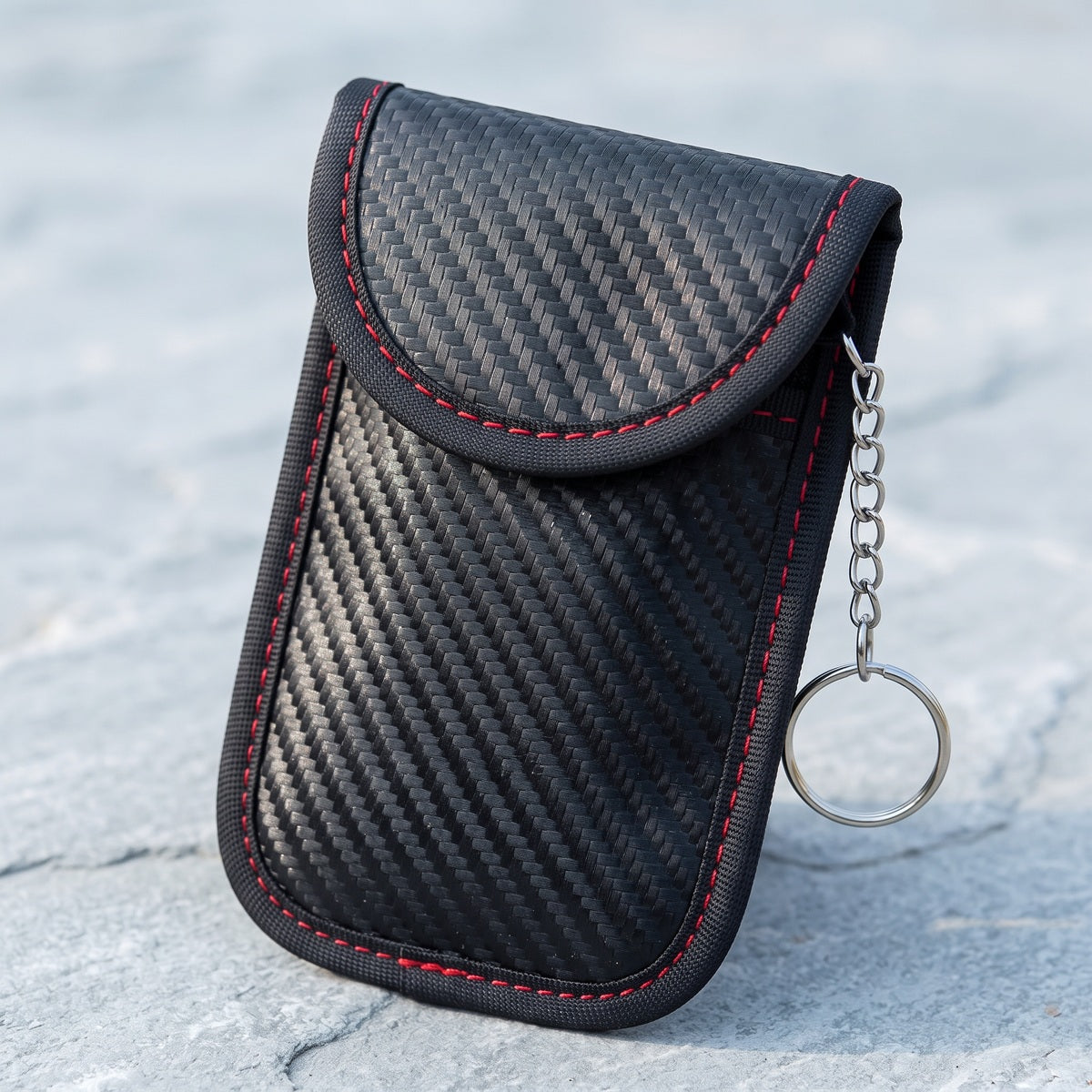 Whole black KeyQuiet pouch on pale grey stone